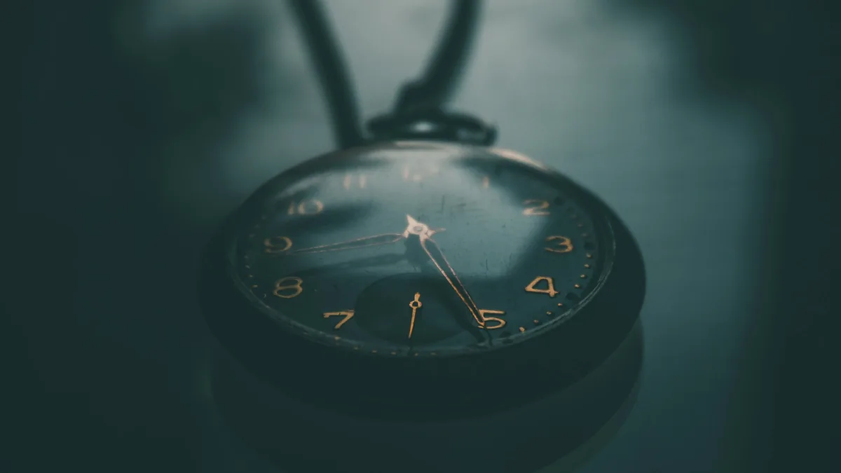 Reloj de bolsillo antiguo sobre un fondo azul verdoso oscuro